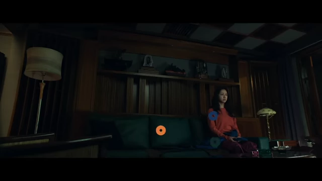Seo-rae sits on a couch with overlaid circles highlighting the red, green, and blue colors, representing characters' differences and similarities (mountain vs. ocean).