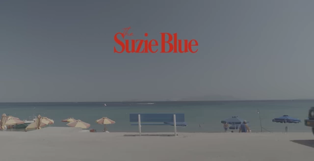 A carousel slide featuring "The Suzie Blue" text in deep orange, demonstrating effective color contrast against a blue sky.