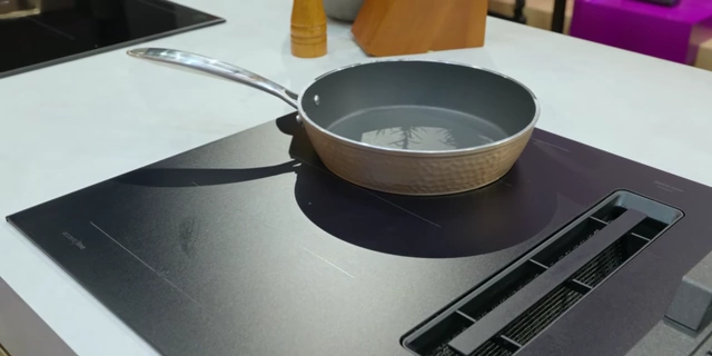 The Bosch 800 series induction cooktop demonstrates AutoChef by precisely maintaining water at a consistent temperature around melting ice cubes.