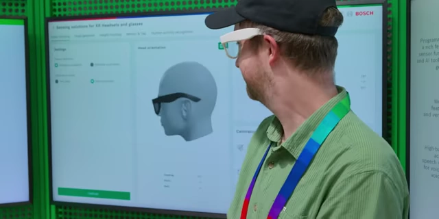 The speaker wearing smart glasses, with a screen displaying real-time head orientation tracking.