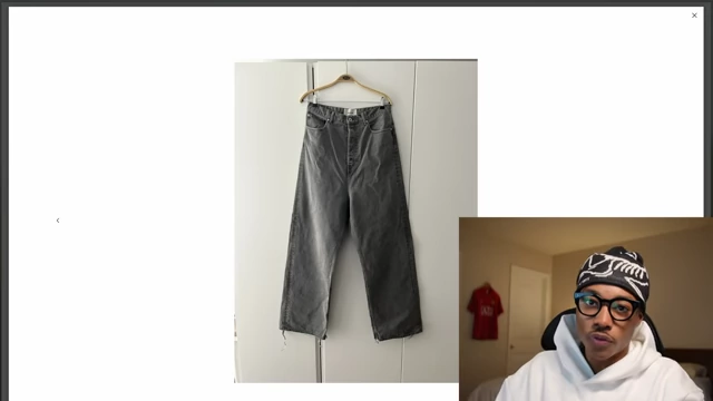 A pair of gray, baggy, wide-leg denim jeans on a hanger