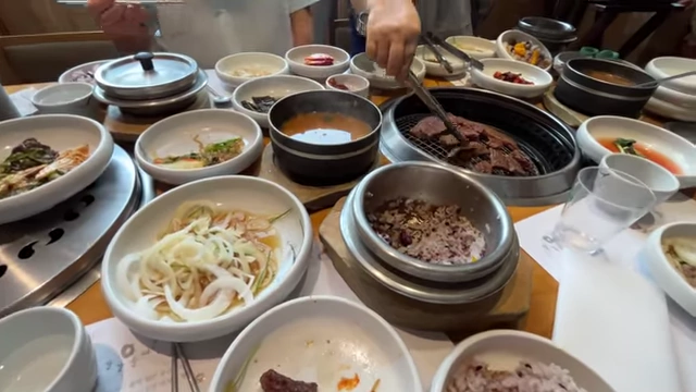 A full spread of Korean barbecue with numerous side dishes