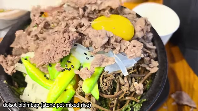 Dolsot bibimbap topped with meat and egg