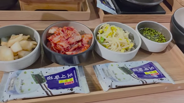 Side dishes including kimchi and bean sprouts served with braised mackerel