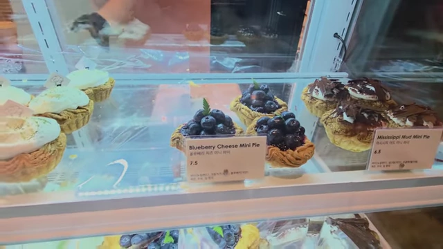 Display of beautiful mini cheese pies, including blueberry and Mississippi mud flavors