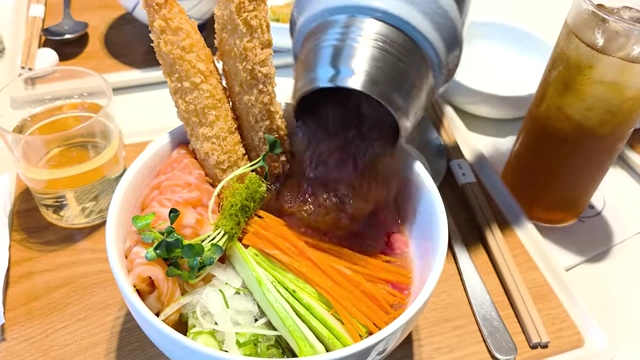 Pouring broth over salmon noodles