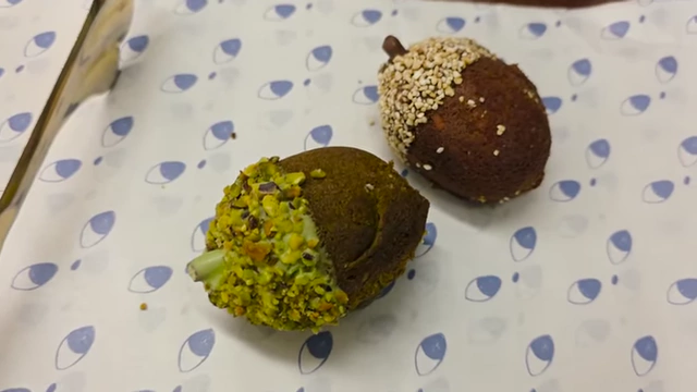Acorn-shaped pastries, one pistachio-matcha and one almond