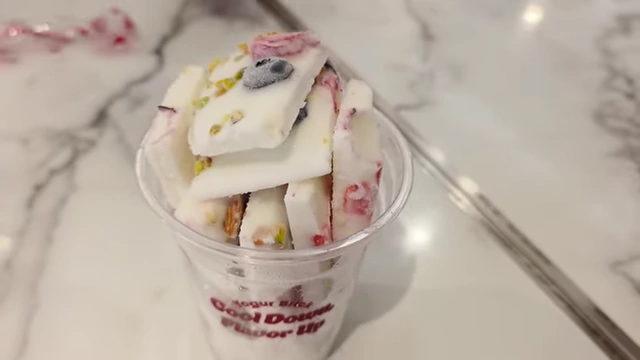 Frozen yogurt brick with nuts and fruit in a cup