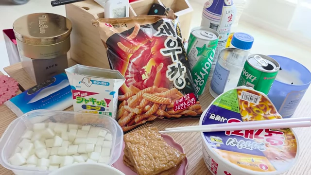 A spread of Korean snacks for the watch party, including cup ramen and shrimp chips