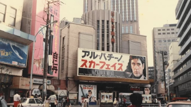 An old photo of a Japanese street with traditional buildings and billboards, suggesting outdated infrastructure.
