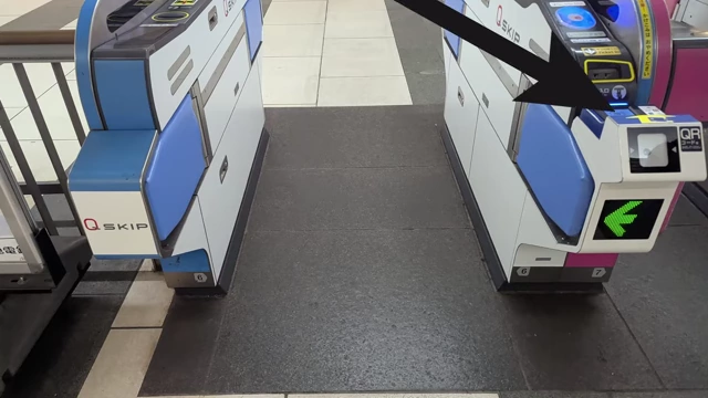 A train station gate with a credit card tap reader highlighted.