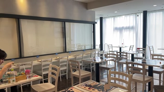 An empty cafe with rows of tables and chairs, showing no other customers.