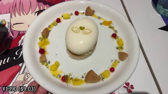 A white, egg-shaped mousse cake decorated with small candies and fruit pieces.