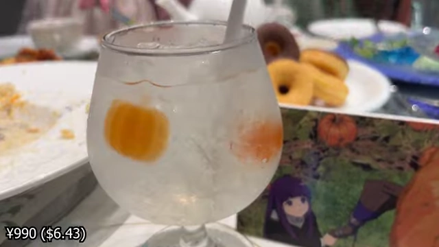 A glass of lemonade with pumpkin-shaped gummies suspended in clear jelly.