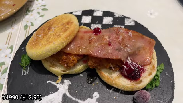 A maple chicken sandwich with bacon, berry sauce, and a sugar art silhouette of dancing characters.