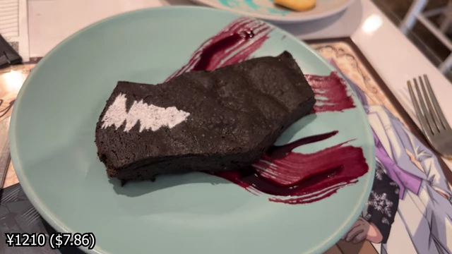 A dark chocolate brownie shaped like a dragon, decorated with a white lightning design and black currant sauce.