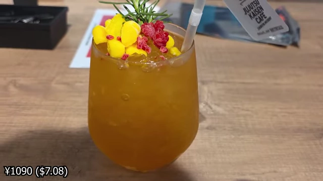 A mango-flavored soda with fruit toppings and a rosemary sprig.