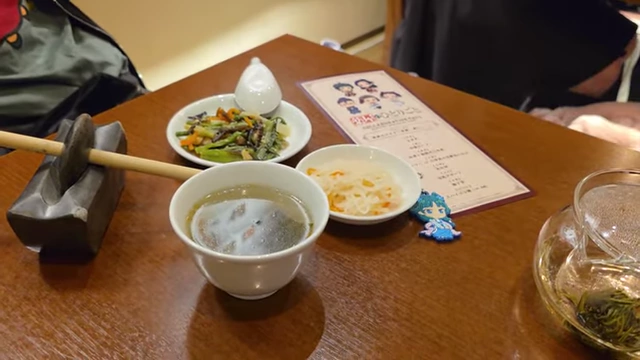 A variety of small dishes forming a course meal, including soup, rice porridge, and various vegetable and meat sides.