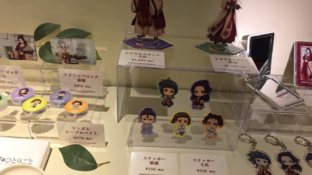A display of merchandise including acrylic blocks, keychains, and a small soy sauce dish.