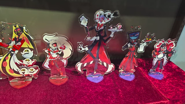 A display of Hazbin Hotel acrylic standees featuring various characters in maid and butler uniforms.