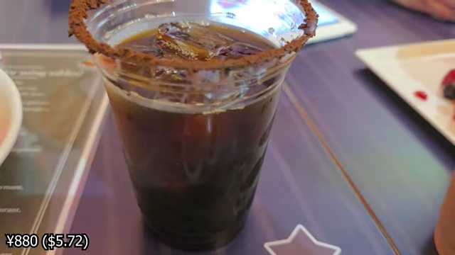An iced coffee with chocolate sauce and coffee powder rimming the glass.