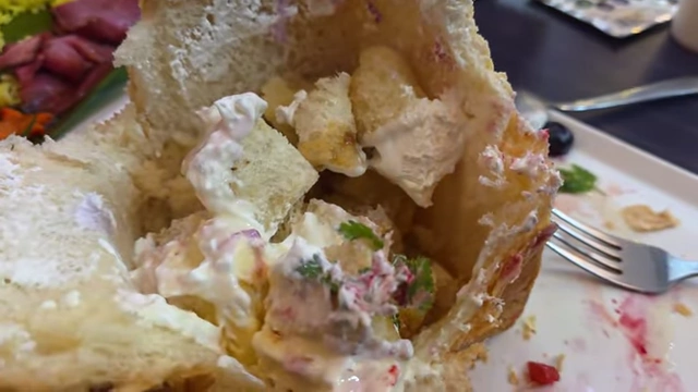 The inside of a hollowed-out honey toast filled with mini toast pieces and cream.