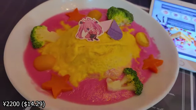 An omurice dish with pink cream sauce, broccoli, carrots, and a character cutout on top.