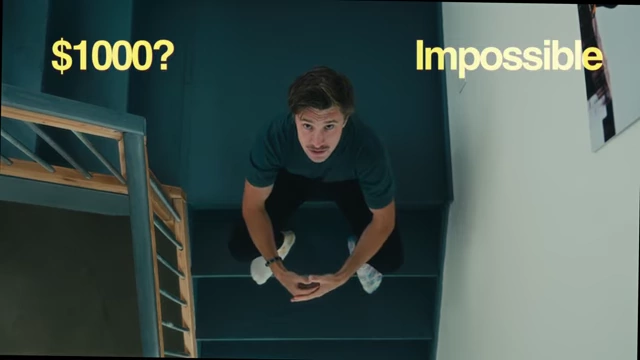 The text "$1000? Impossible" overlaid on Evan looking up, illustrating his financial struggles.