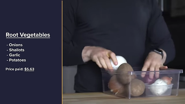 A clear bin filled with various root vegetables including onions, shallots, garlic, and potatoes, with their total cost