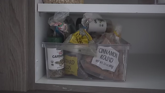 A clear bin storing overflow spices for refilling bottles