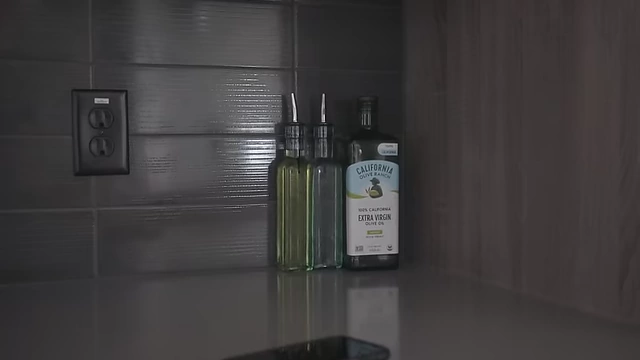 Small bottles of olive oil and peanut oil stored on the kitchen counter away from heat