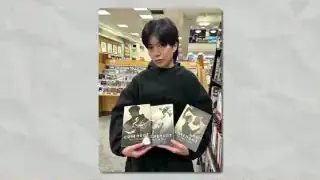 The artist holding published copies of her WebToon series, Covenant.