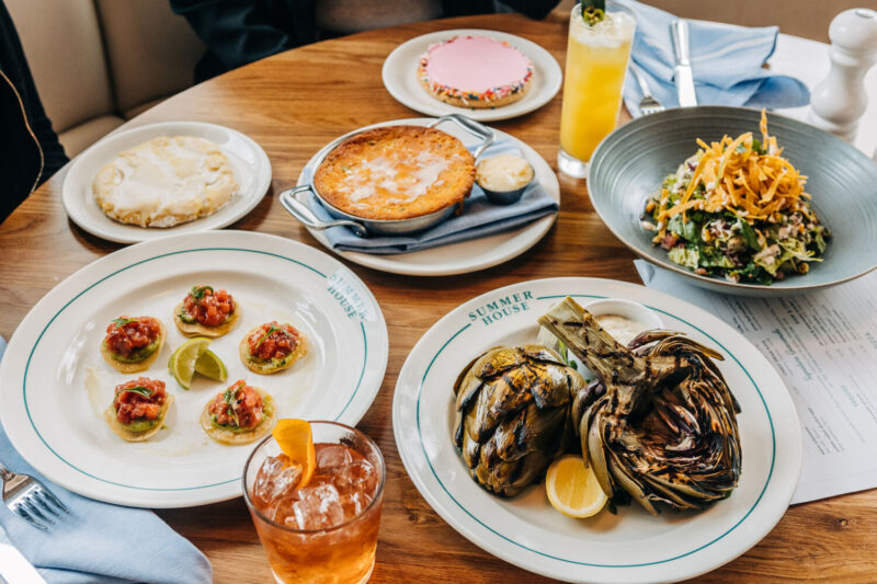 Group shot of Tuna Tostadas, Grilled Artichoke, Cornbread, Costa Mesa Salad, cookies and a mocktail