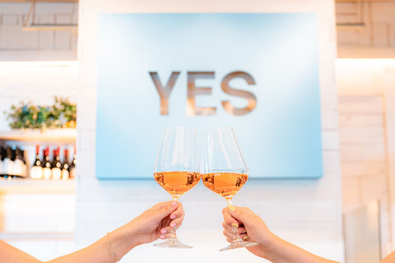 Two people cheersing glasses of Rosé, available at the Taste of California