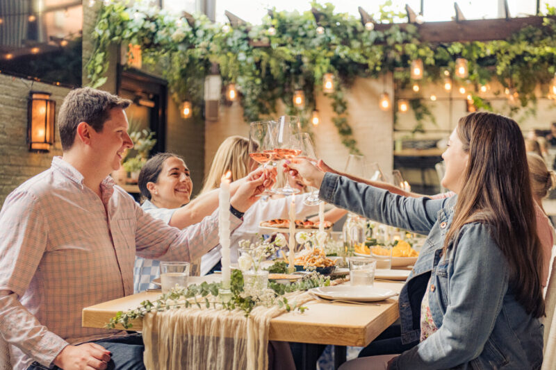 Group of guests cheersing glasses of rosé at the Summer Nights Supper Club Series