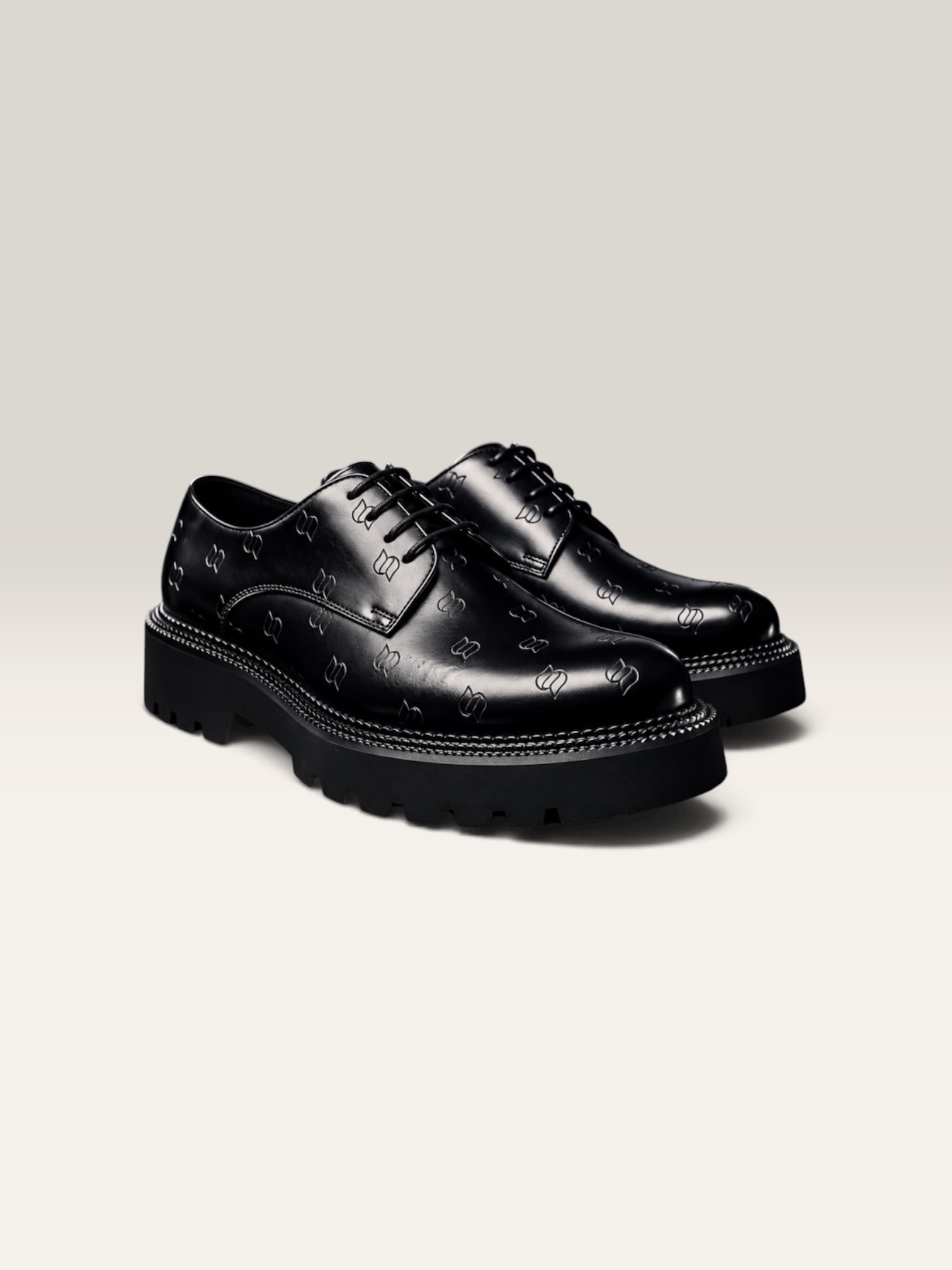 A pair of indigo-black leather shoes photographed on a wooden surface