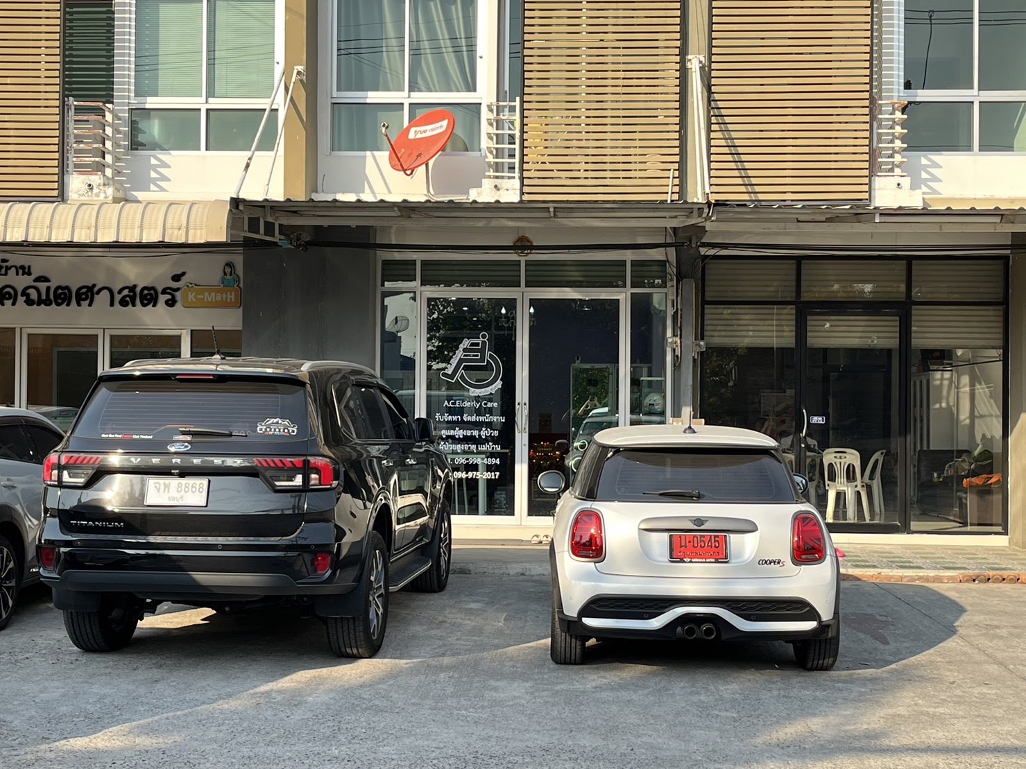 Car parked outside a restaurant as customers gather near the entrance