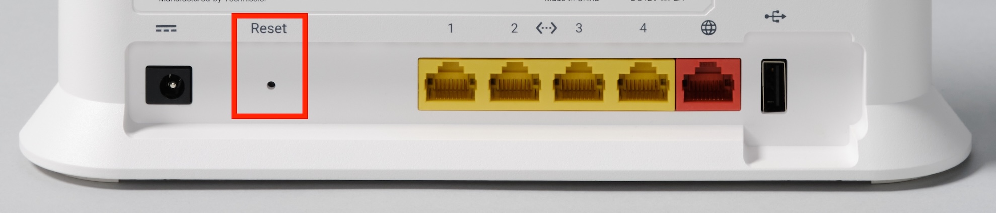 The back of the Google Fiber Wi-Fi 6 Router (GRAX210T). The Reset pinhole, near the bottom left edge of the device, is circled in red.