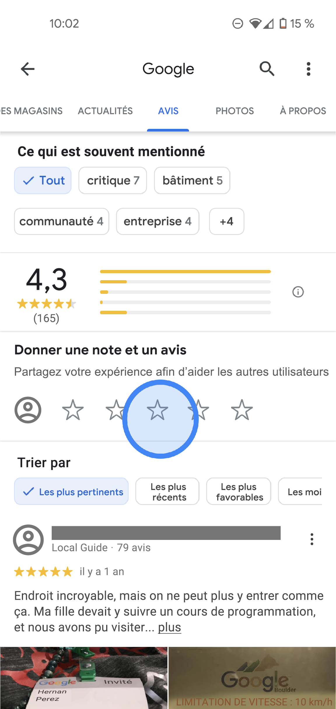 Dans l'application Google Maps, l'onglet "Avis" d'un bureau Google s'affiche. En haut de l'écran se trouvent les onglets "Liste", "Avis", "Photos" et "À propos". En dessous, vous avez accès à des informations telles que la note moyenne, la répartition des notes et la liste de tous les avis. Au milieu de l'écran se trouve la section "Note et avis", accompagnée de cinq étoiles vides. 