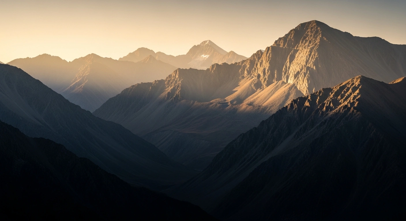 A wide-angle shot of the rugged Kunlun Mountains at dawn, with golden light illuminating the peaks and a subtle shimmer on a distant rock face, representing China's discovery of a 1,000-tonne gold belt in Xinjiang.