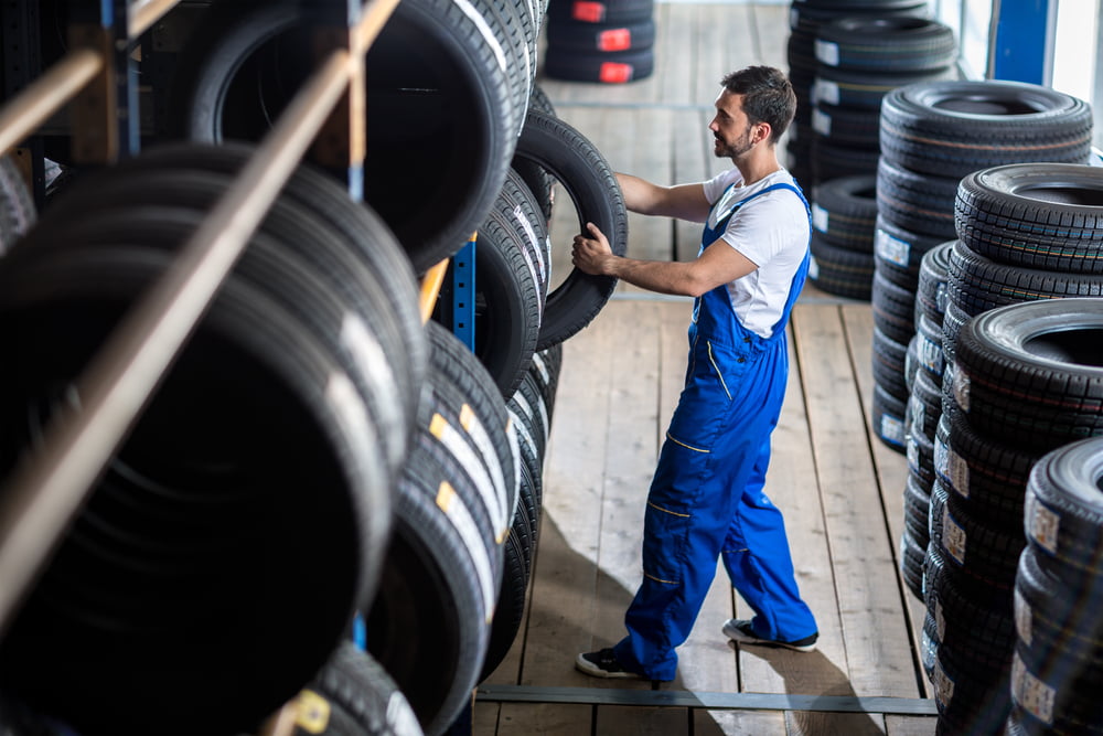 a mechanic removing a tire from the warehouse wall