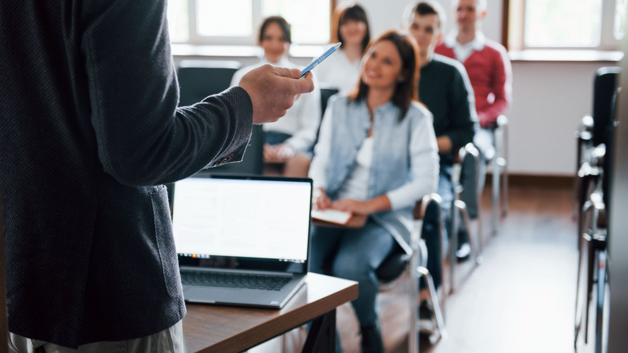 648c0a4cb3ddd__everyone-is-smiling-and-listens-group-of-people-at-business-conference-in-modern-classroom-at-daytime.jpg