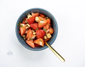 Strawberry fruit salad with mint and hazelnuts
