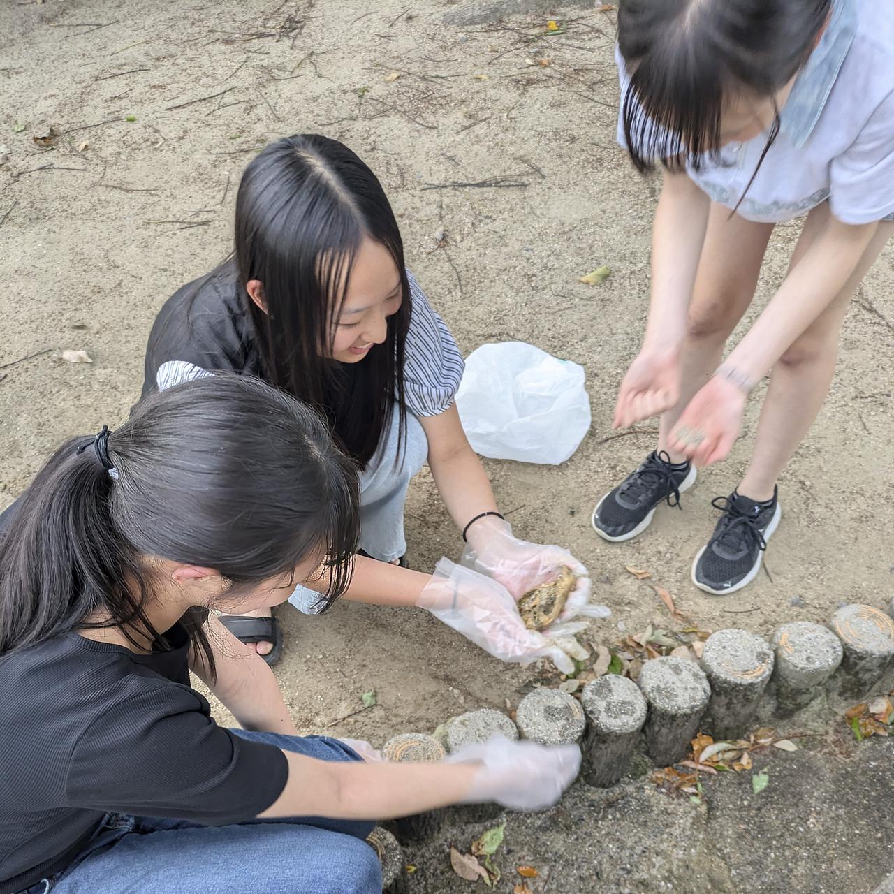 川のゴミ拾いで拾った、何かの骨を洗う中学生。