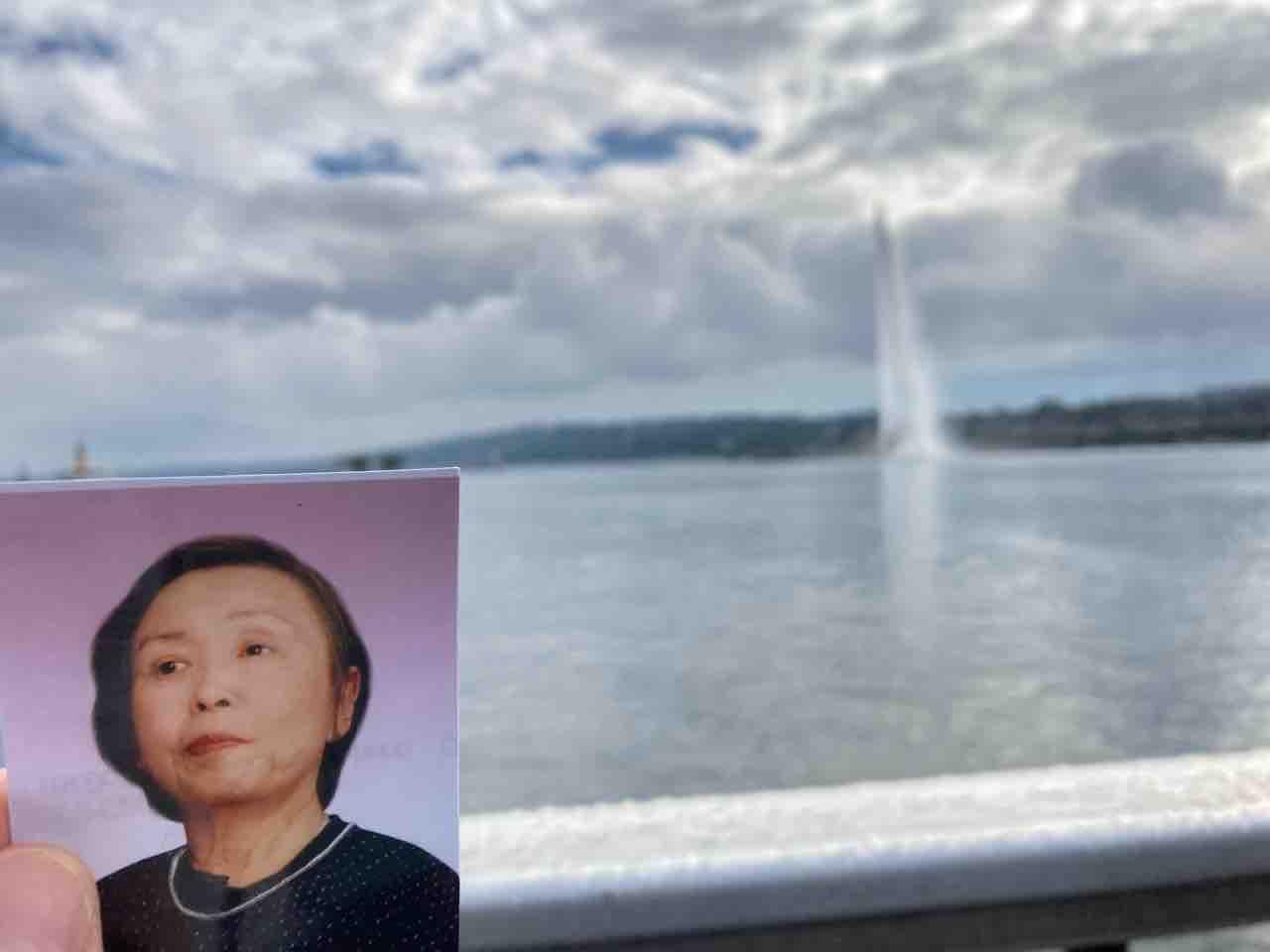 ジュネーブのレマン湖を背景に、左隅に手のひらサイズの母の遺影。
