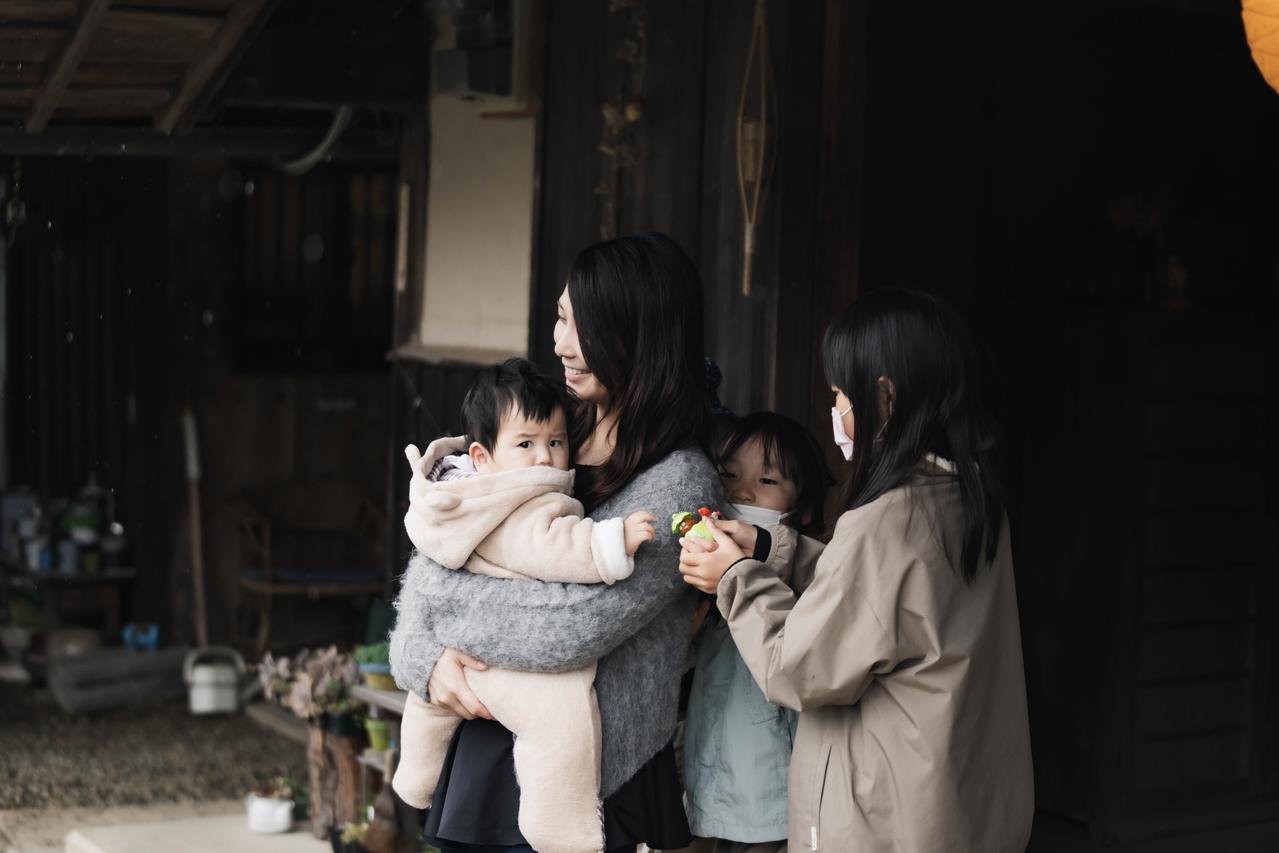 赤ちゃんを抱っこする笑顔の女性と子どもたち