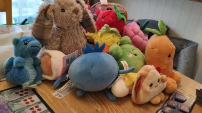 A bunny with tartan ears behind a pile of plushie food.