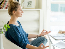 Mlada žena sjedi pred računalom i počinje s meditacijom