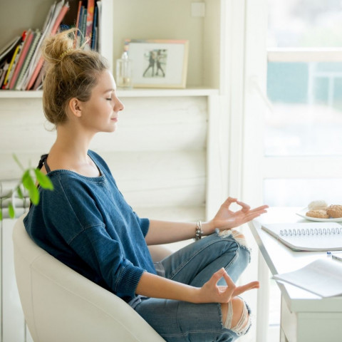 Kako početi s meditacijom Mlada žena sjedi pred računalom i počinje s meditacijom