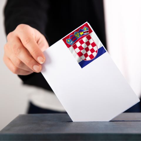 Žena ubacuje glasački listić na izborima Republike Hrvatske u kutiju